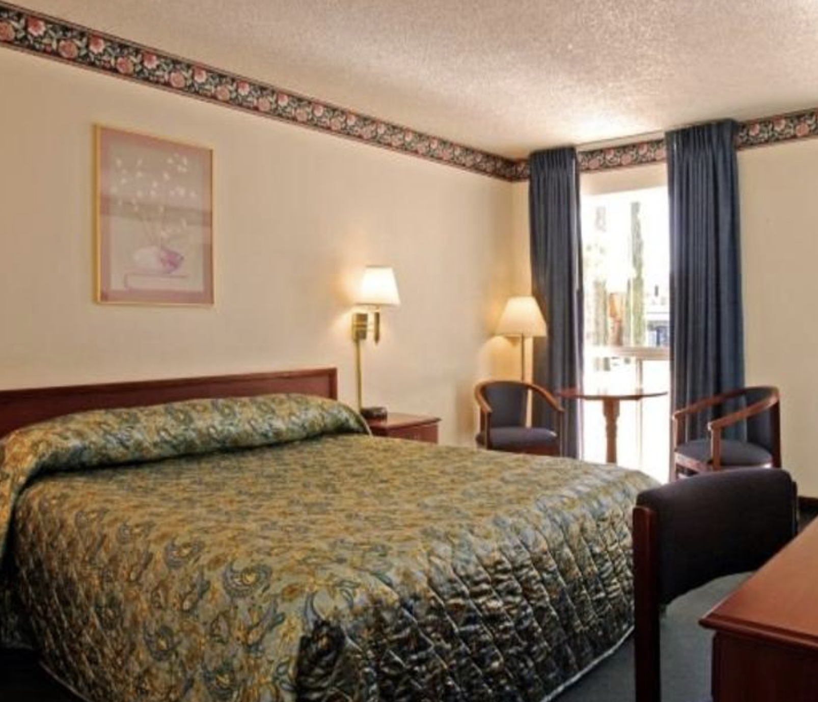 Queen Bed room with seating at El Dorado Inn Suites